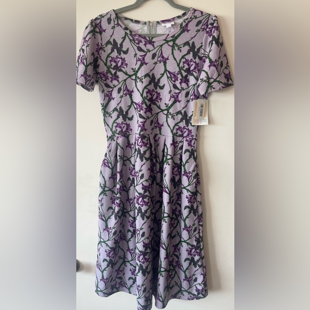 Short sleeved dress with pretty pleats and pockets.